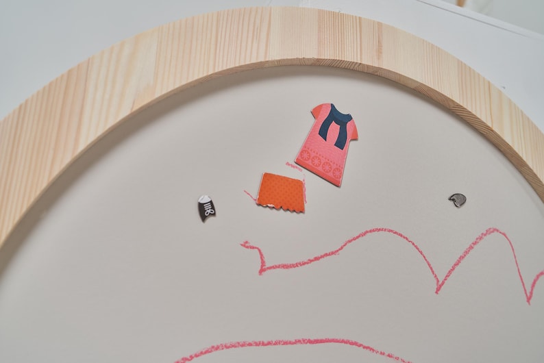 Magnets attached to a magnetic chalkboard surface for creative learning and play