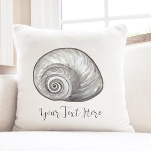 May include: White throw pillow with a gray and white seashell illustration and the text "Your Text Here".