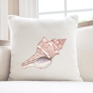 May include: A white throw pillow with a brown and white seashell illustration.