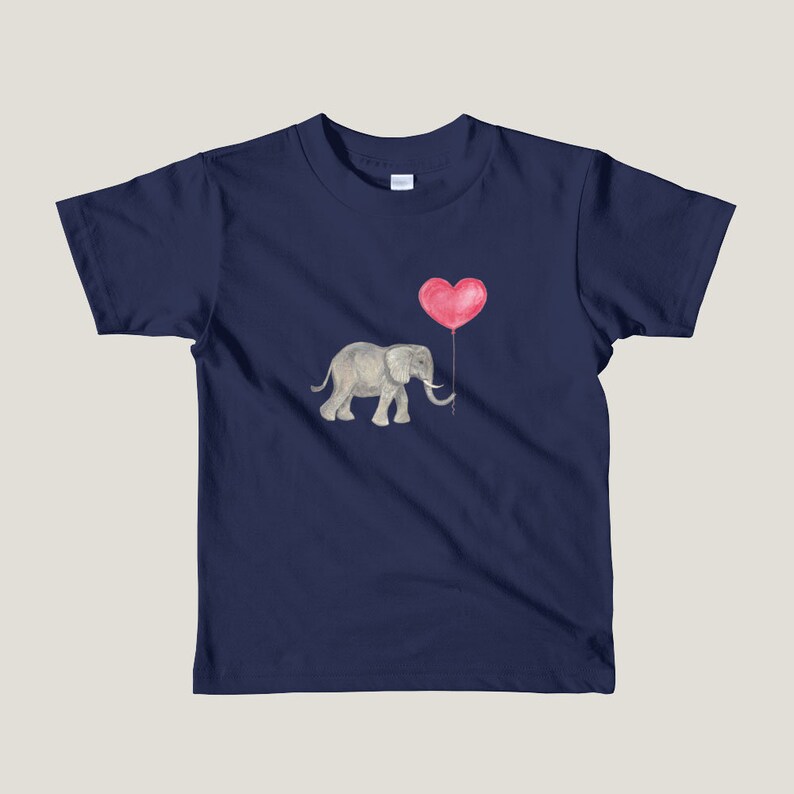 K&ouml;nnte beinhalten: Ein marineblaues Kinder-T-Shirt mit einem grauen Elefanten, der einen roten herzf&ouml;rmigen Ballon h&auml;lt.