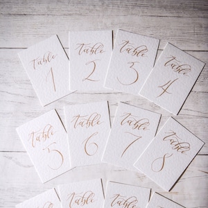Hand lettered calligraphy table names/numbers - CLEAN range - on white hammered card