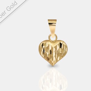 May include: A small, gold heart-shaped pendant with a textured surface. The pendant is made of 585er gold.