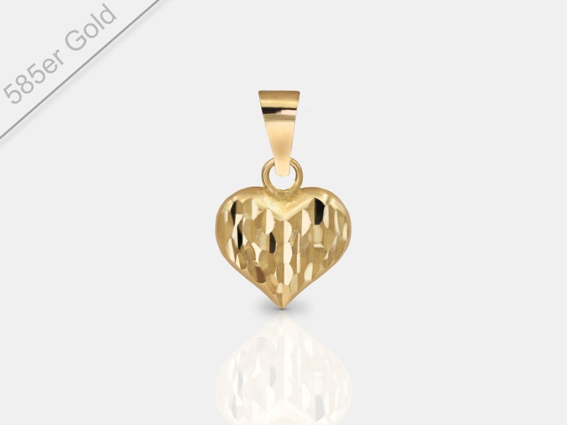 May include: A small, gold heart-shaped pendant with a textured surface. The pendant is made of 585er gold.