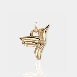 Pode incluir: Um pingente de beija-flor dourado. O beija-flor est&aacute; em voo com as asas abertas. O pingente tem um la&ccedil;o na parte superior para prender a um colar ou pulseira.