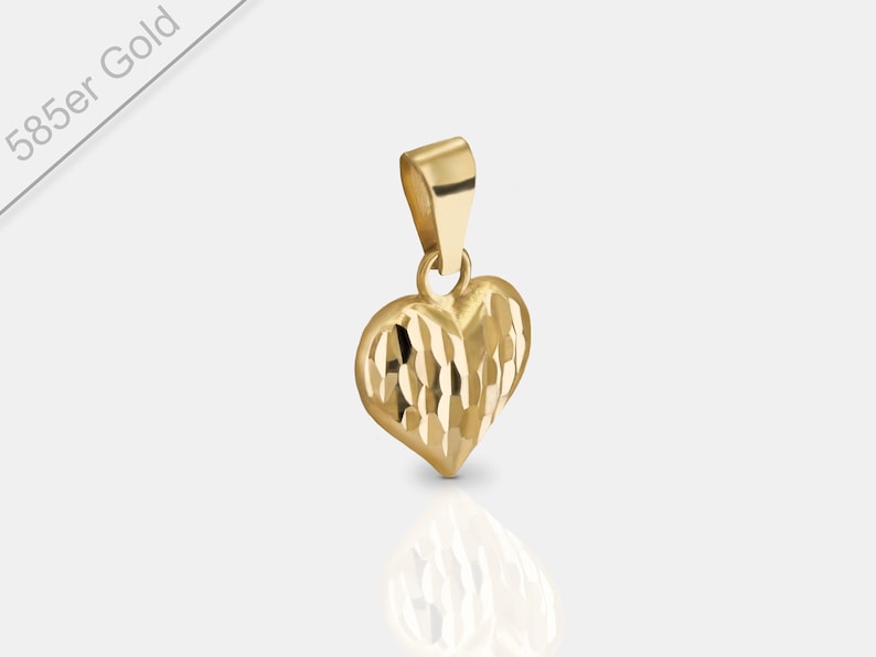 May include: A gold heart-shaped pendant with a textured surface. The pendant is made of 585er gold.
