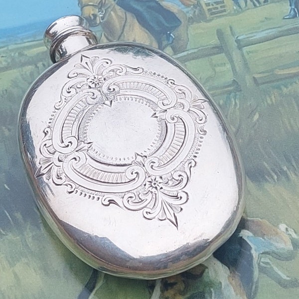 A superb example of Edwardian silver plate, manufactured by James Dixon this hip flask is highly detailed with engraved scroll work.