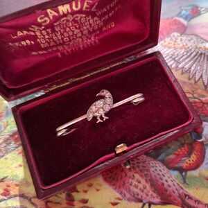 A 1920s silver brooch in the form of a bird, dappled with faux diamonds and a ruby glass eye, of fieldsports interest, perfect for a tie pin