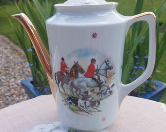 A coffee pot, absolutely stunning with an English fox hunting scene to decorate. The horse and hound design  complemented with gilded rims.