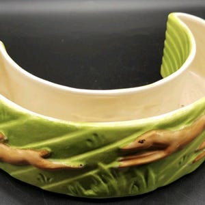 An early 20th century shallow posy vase of hare coursing interest, featuring long dogs and running hares. Dog and rabbit planter in green.