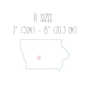 May include: A line drawing of the state of Iowa in teal with a red star in the center. The text "2" (5CM) – 8" (20.3 CM) and "SIZIS" is written in black above the state outline.