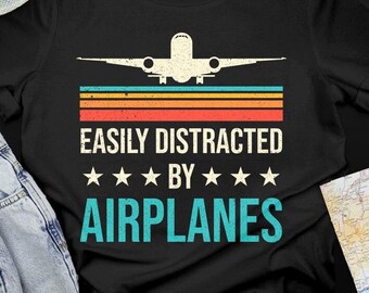 May include: Black t-shirt with a vintage airplane graphic and the text "Easily Distracted by Airplanes".