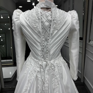 Pearl beaded satin gown with an adjustable corset back, elegant bridal structure and refined modest styling