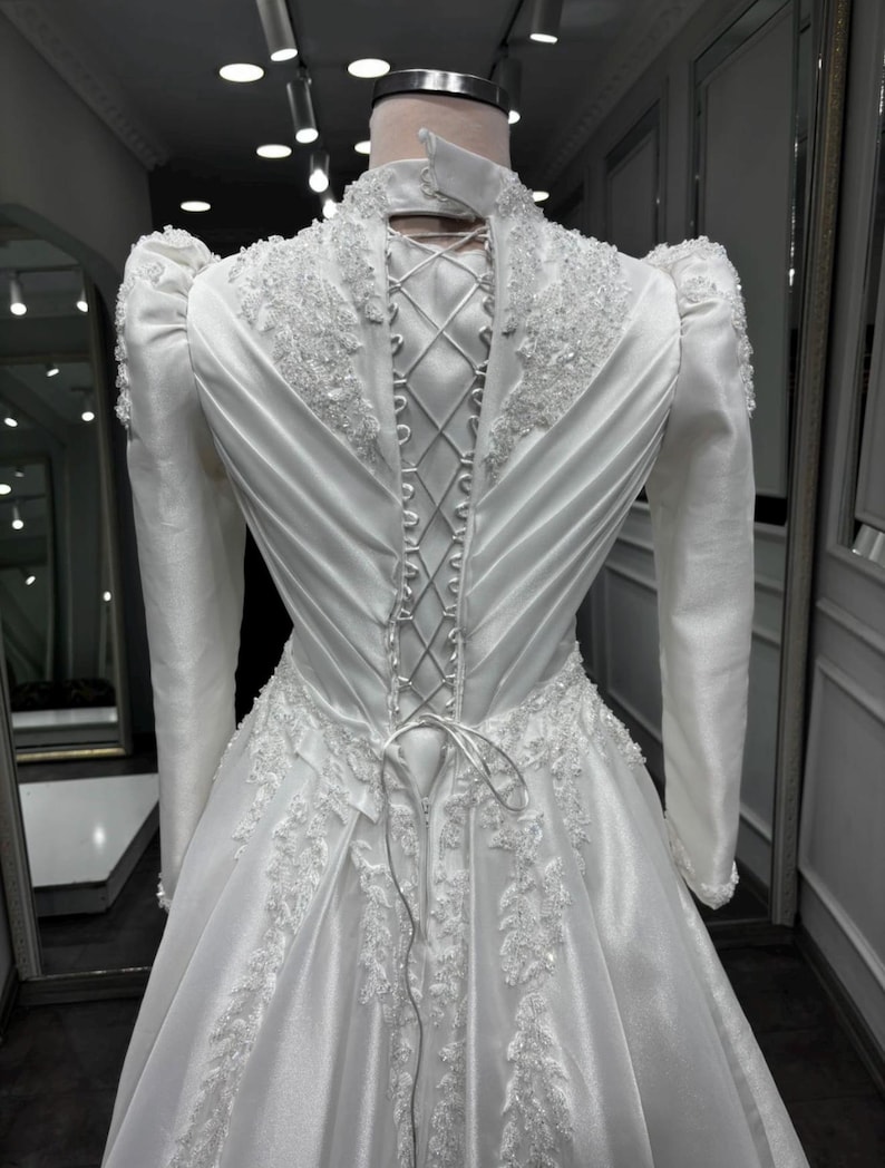 Pearl beaded satin gown with an adjustable corset back, elegant bridal structure and refined modest styling