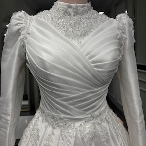 Draped bodice satin bridal gown with romantic detailing and sophisticated bridal style
