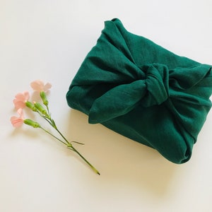 Ciemnozielona lniana tkanina do pakowania furoshiki. Ekologiczna tkanina furoshiki w rozmiarze małym, średnim i dużym. Zrównoważone opakowanie prezentów na święta.