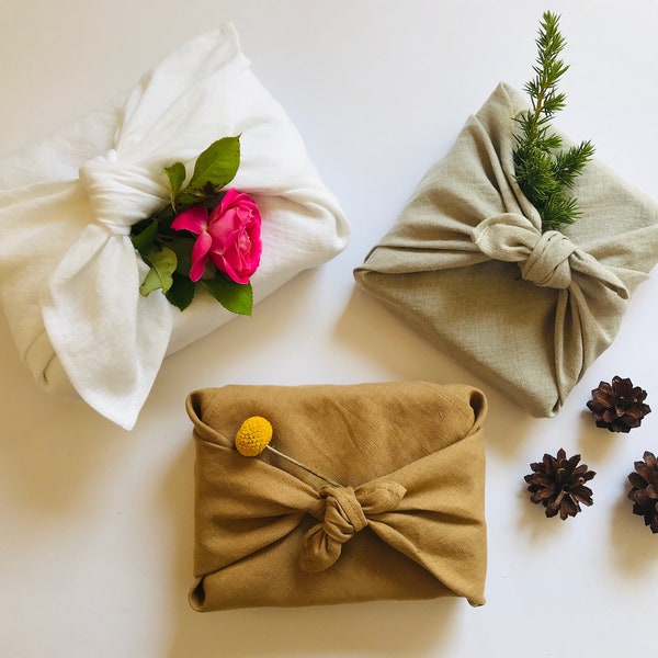 Furoshiki wrapping cloth in natural, white, peanut brown linen. Sustainable reusable gift wrap for holidays in earth tones, neutral colours.