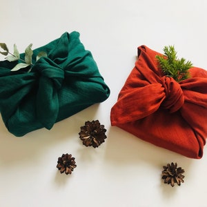 Linen gift wrapping cloth for Christmas. Furoshiki wrapping cloth in red or green colours. Sustainable fabric gift wrap for holidays.