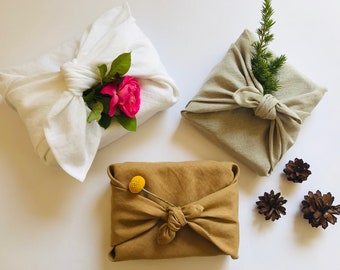 Furoshiki wrapping cloth in natural, white, peanut brown linen. Sustainable reusable gift wrap for holidays in earth tones, neutral colours.