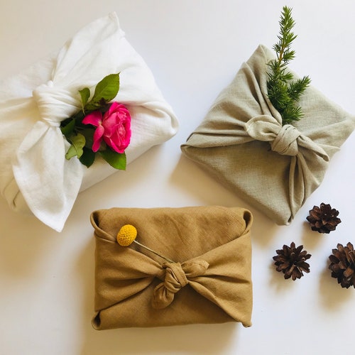 Furoshiki wrapping cloth in natural, white, peanut brown linen. Sustainable reusable gift wrap for holidays in earth tones, neutral colours.