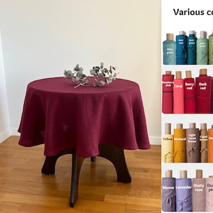 May include: A burgundy linen tablecloth on a round wooden table with a small bouquet of eucalyptus leaves. The image also shows a variety of fabric swatches in different colors, including green, red, purple, yellow, orange, brown, pink, and lavender. The text "Various colours" is displayed at the top of the image.