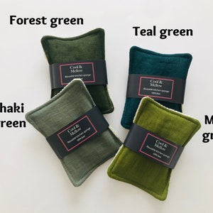 May include: Four reusable kitchen sponges in different shades of green: forest green, teal green, khaki green, and moss green. Each sponge has a black label with the text "Cool & Mellow Reusable Kitchen Sponge 100% linen".