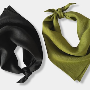 Puede incluir: Dos bandanas de tela, una negra y otra verde oliva. Ambas están dobladas y atadas en un nudo.