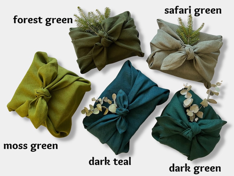 May include: Five fabric gift wraps in different shades of green, including forest green, safari green, moss green, dark teal, and dark green. Each wrap is tied with a knot and decorated with a sprig of greenery.