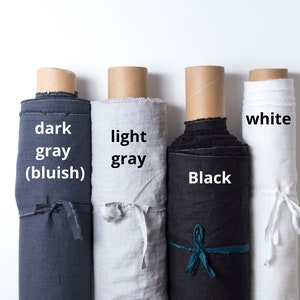 May include: Four rolls of fabric in different colors: dark gray (bluish), light gray, black, and white. The fabric is rolled up and tied with a ribbon.