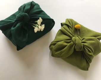 Green reusable gift wrap with fabric. Zero waste furoshiki wrapping cloth. Linen furoshiki cloth. Eco-friendly gift wrapping alternatives.