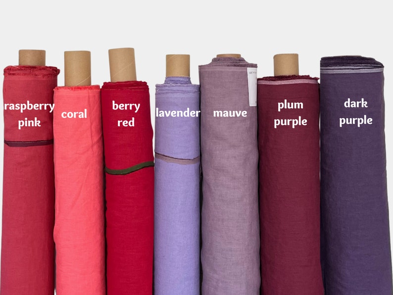 May include: Eight rolls of fabric in various shades of pink, red, purple, and lavender. The fabric is labeled with the colors: raspberry pink, coral, berry red, lavender, mauve, plum purple, and dark purple.