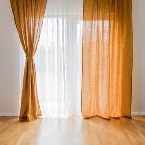 K&ouml;nnte beinhalten: Ein Fenster mit zwei Gardinen. Ein Satz ist aus wei&szlig;en, durchsichtigen Gardinen und der andere aus senfgelben Leinenvorh&auml;ngen. Die Gardinen sind zugezogen und das Fenster l&auml;sst nat&uuml;rliches Licht herein.