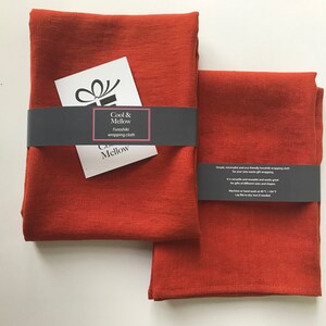 May include: Two rust-colored fabric squares, folded and stacked. The top square has a black label that reads "Cool & Mellow" and "Furoshiki wrapping cloth".