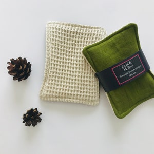 May include: Two reusable kitchen sponges, one white waffle weave and one green, with a black label that reads "Cool & Mellow Reusable kitchen sponge 100% flax"