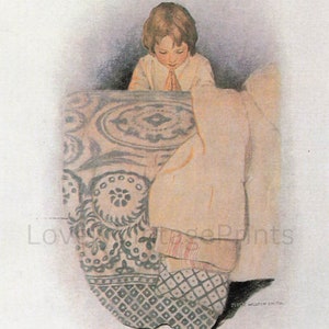 May include: A young child in a white shirt with a tie is kneeling and praying at the edge of a bed with a patterned quilt. The quilt has a white background with blue and green floral designs.