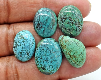 May include: Five oval-shaped turquoise cabochons with a blue-green color and a spiderweb pattern. The stones are various sizes and have a smooth, polished finish.