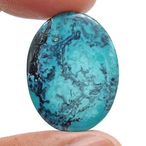 May include: Oval turquoise cabochon with a blue-green colour and black veins. The stone has a smooth, polished surface.