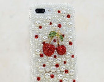 Op de afbeelding: Witte iPhone-hoesje bedekt met witte parels en rode strass steentjes met een kersenontwerp in het midden.