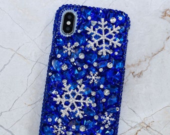 Op de afbeelding: Een blauwe telefoonhoes met een sneeuwvlokkenontwerp. De hoes is bedekt met strass.
