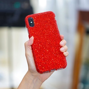 May include: A red phone case covered in sparkling rhinestones.