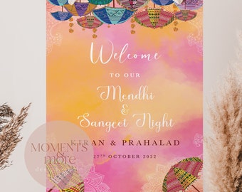 May include: A decorative sign with a watercolor background in shades of pink and orange. The sign reads "Welcome to our Mendhi & Sangeet Night" with the names Kiran & Prahlad and the date October 27th, 2022. The sign is adorned with colorful umbrella illustrations.
