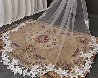 May include: A long white bridal veil with a delicate lace trim. The veil is made of soft tulle and has a cathedral length.