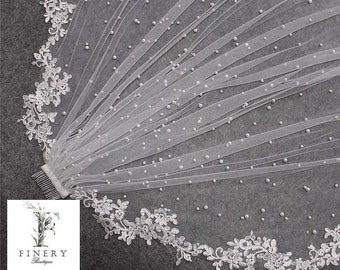 May include: A white bridal veil with a delicate lace trim and pearl embellishments. The veil is attached to a comb for easy wear.