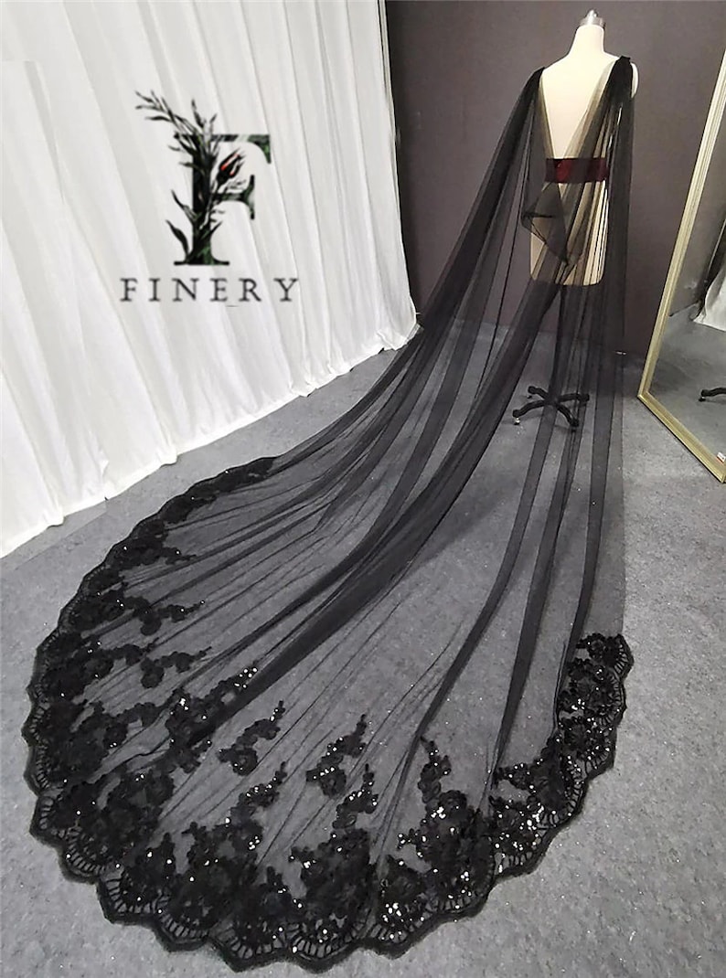 May include: Black tulle wedding veil with a scalloped edge and black sequin embroidery. The veil is long and flowing, and it would be a beautiful addition to any wedding.