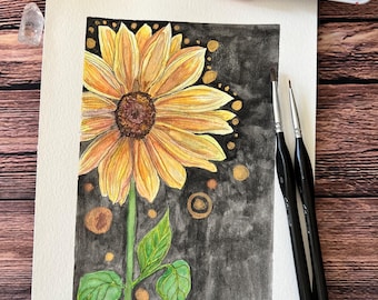 May include: Watercolor painting of a sunflower with yellow petals and a dark brown center. The sunflower is on a black background with gold accents. The painting is signed "Naomi".