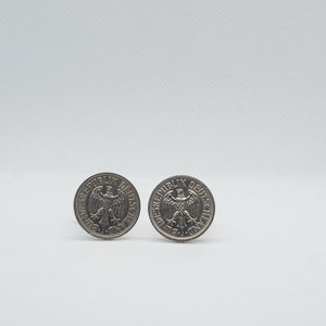 May include: Two silver German coins with the German eagle on the front. The coins are on a white background.