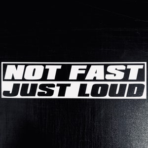Może przedstawiać: Czarno-biała naklejka z tekstem "NOT FAST JUST LOUD" na czarnym tle.