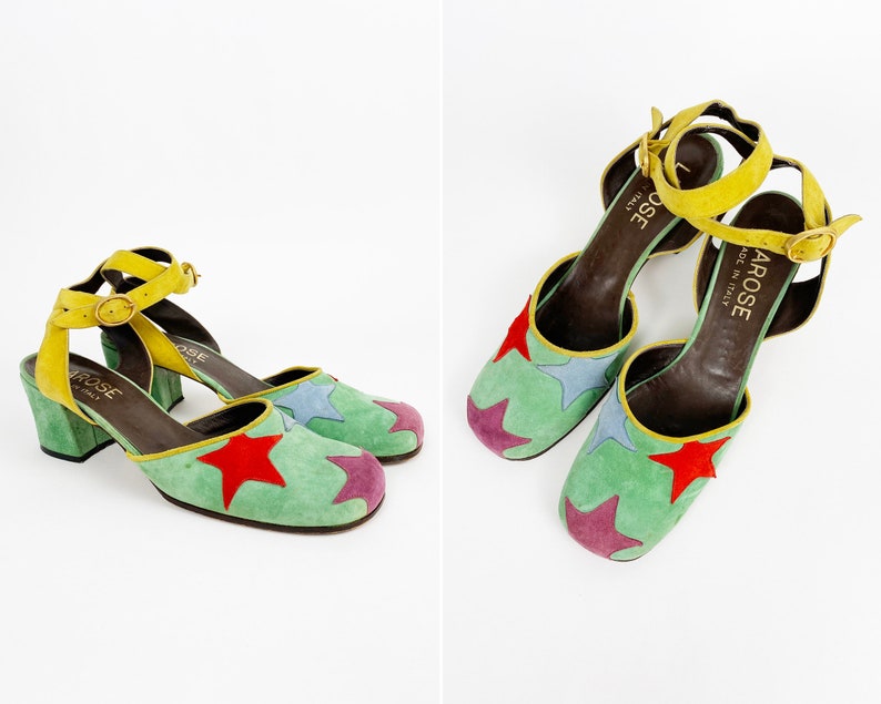 May include: A pair of green suede heeled shoes with a yellow ankle strap and multi-colored star accents. The shoes are labeled "Arose Made in Italy".