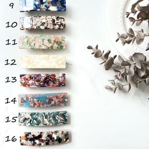 May include: A set of eight colorful hair clips with different patterns. The clips are made of a translucent material with a marbled effect. The clips are numbered 9 through 16.