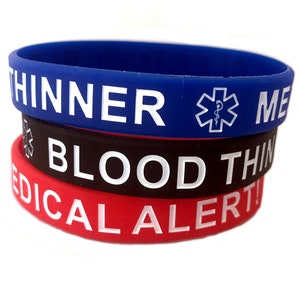 May include: Three silicone medical alert bracelets stacked on top of each other. The top bracelet is blue with white text that reads "THINNER" and a medical symbol. The middle bracelet is black with white text that reads "BLOOD THINNER". The bottom bracelet is red with white text that reads "MEDICAL ALERT!"