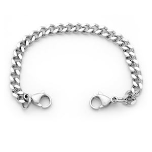 May include: A silver curb chain bracelet with a lobster clasp closure.